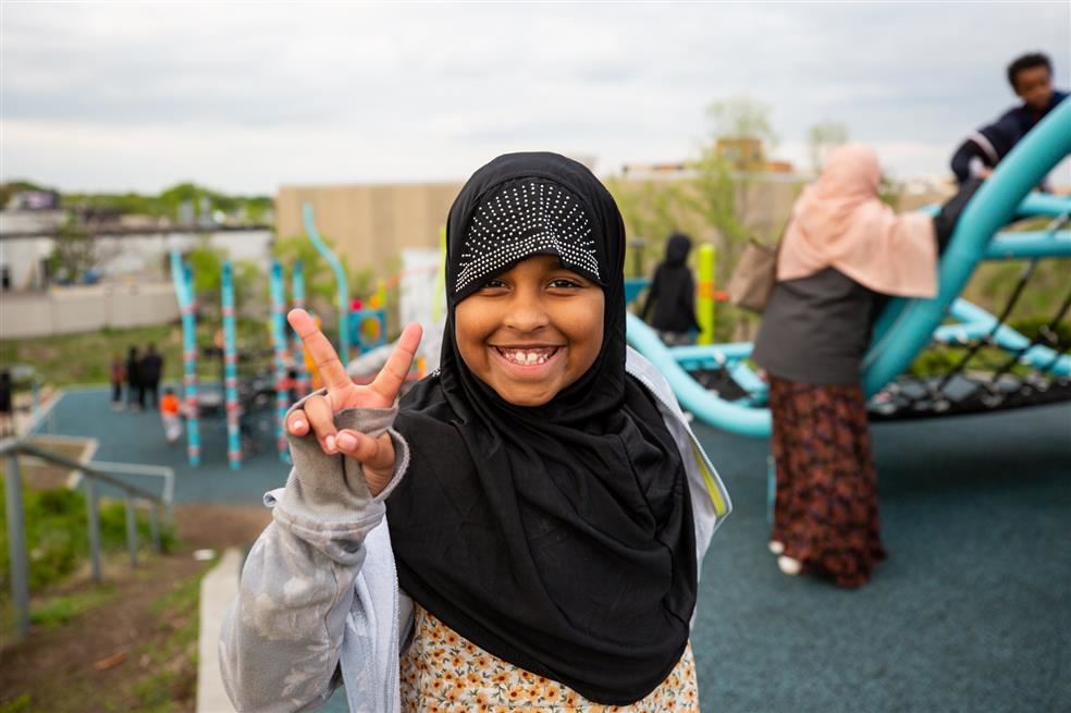 African girl wearing hijab giving peace sign.